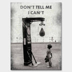 Motywacyjny obraz na płótnie Don’t Tell Me I Can’t – dziecko w rękawicach bokserskich patrzące na worek treningowy, symbol odwagi i determinacji.
