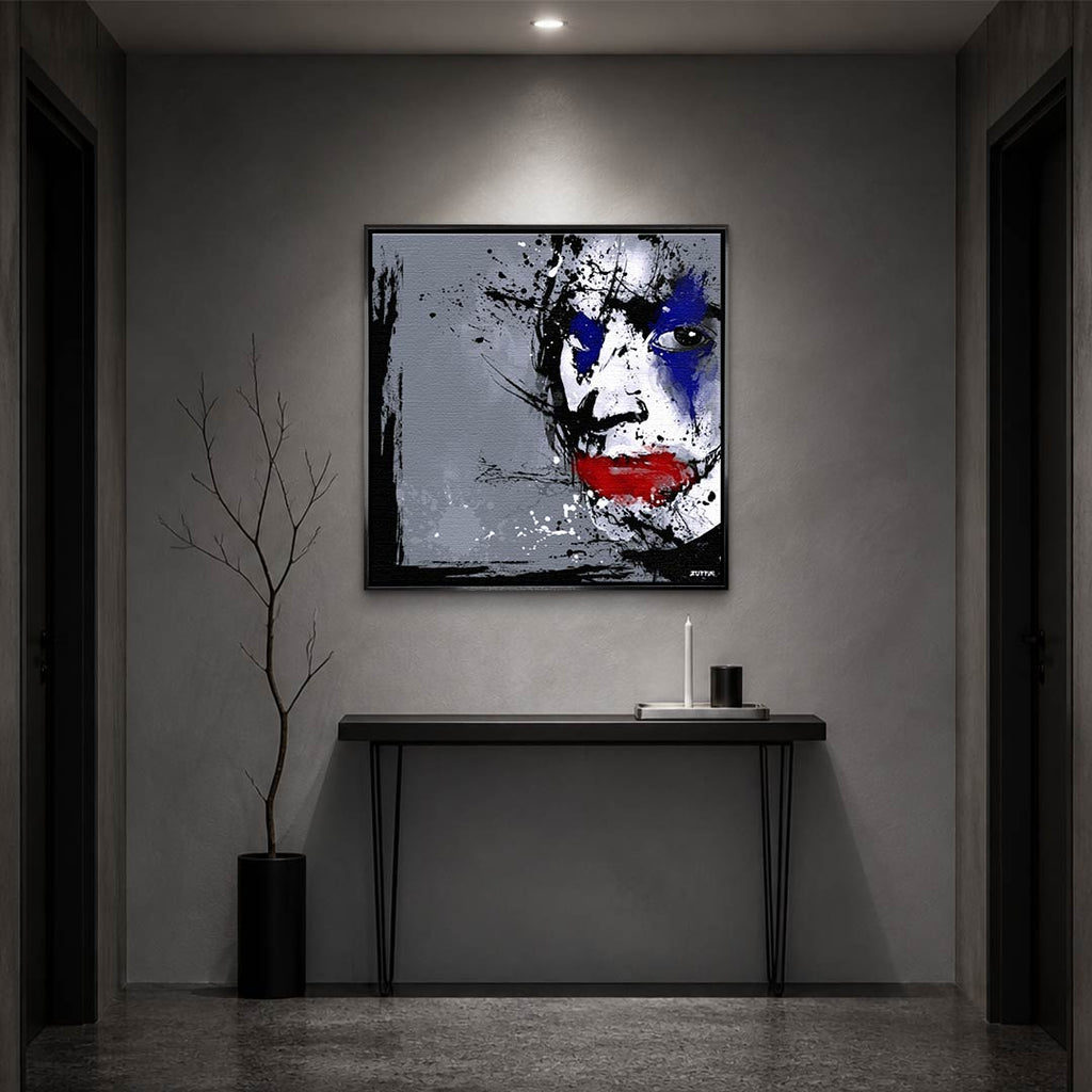 Obraz na płótnie z twarzą Jokera w stylu splash art. Nowoczesny wydruk galeryjny w kolorach szarym, niebieskim i czerwonym. Kunst pop-art.