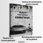 Obraz motywacyjny na płótnie „Make Your Dreams Come True” – czarno-biała scena z Lamborghini i chłopcem na rowerze, z napisem motywacyjnym.