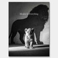 Czarno-biały obraz na płótnie Lion Mindset marki Huephant. Wydruk galeryjny przedstawiający lwiątko rzucające cień wielkiego lwa w czarnej ramie.