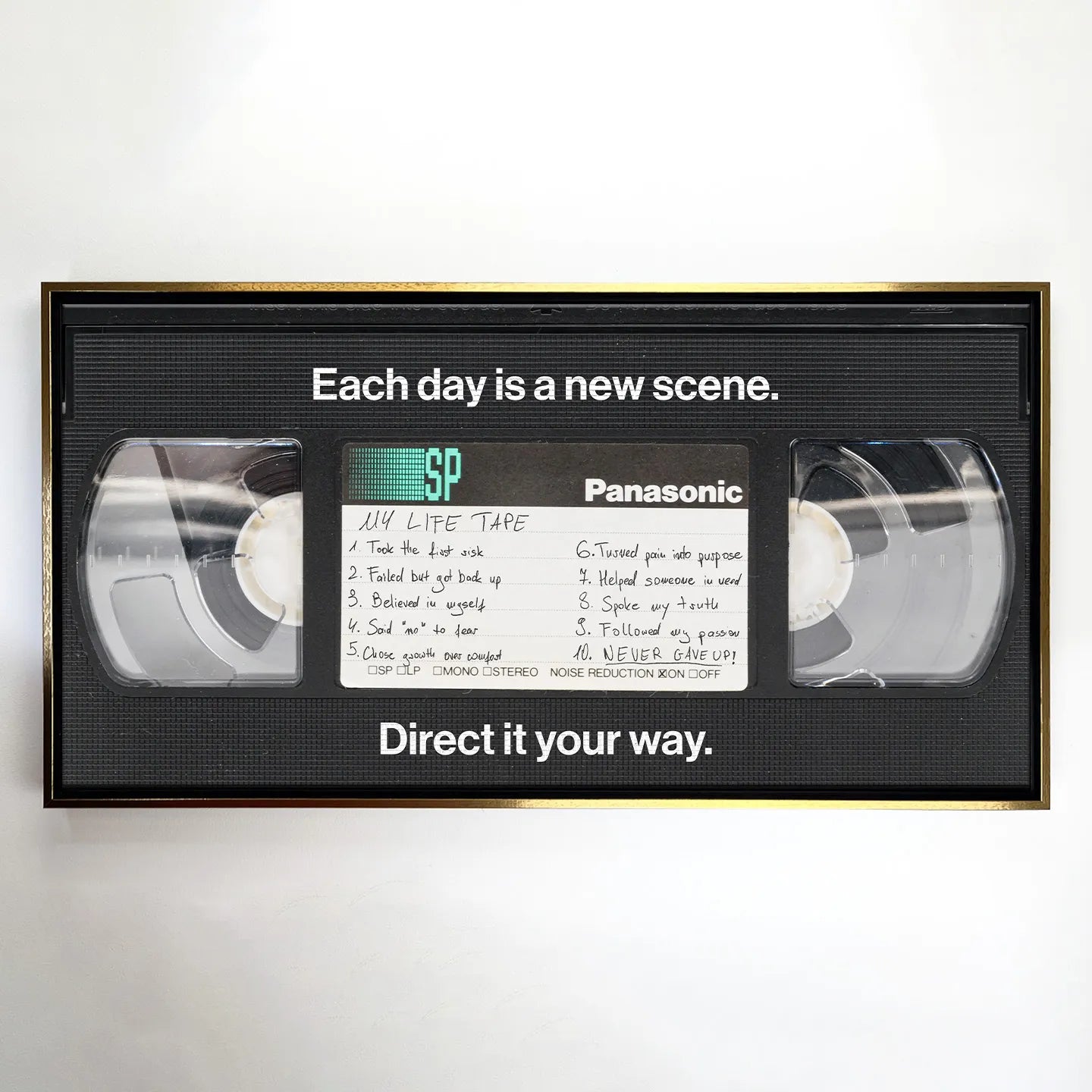 Obraz na płótnie "My Life Tape" przedstawiający kasetę VHS z inspirującymi hasłami o życiu, takimi jak "Never gave up" i "Each day is a new scene" – nowoczesna dekoracja ścienna w stylu retro z motywem motywacyjnym
