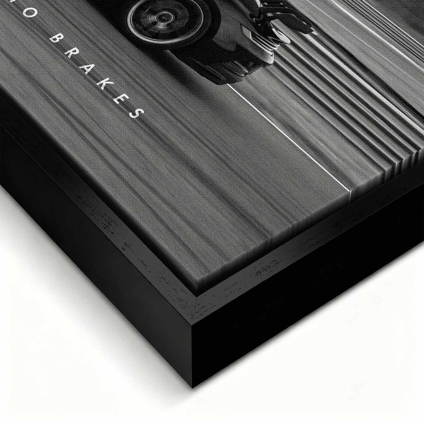 Czarno-biały obraz na płótnie przedstawiający Porsche 911 w szybkim ruchu na torze z napisem Success Has No Brakes. Motywacyjna sztuka ścienna do biura.