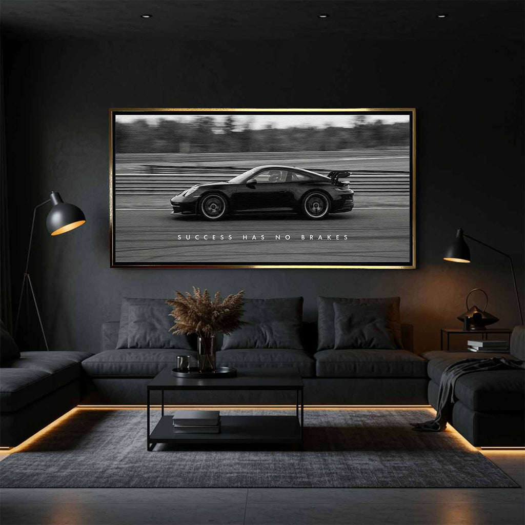 Czarno-biały obraz na płótnie przedstawiający Porsche 911 w szybkim ruchu na torze z napisem Success Has No Brakes. Motywacyjna sztuka ścienna do biura.