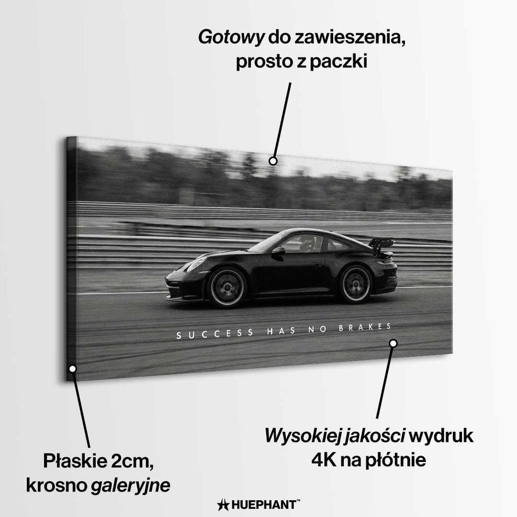 Czarno-biały obraz na płótnie przedstawiający Porsche 911 w szybkim ruchu na torze z napisem Success Has No Brakes. Motywacyjna sztuka ścienna do biura.