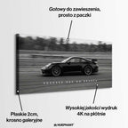 Czarno-biały obraz na płótnie przedstawiający Porsche 911 w szybkim ruchu na torze z napisem Success Has No Brakes. Motywacyjna sztuka ścienna do biura.