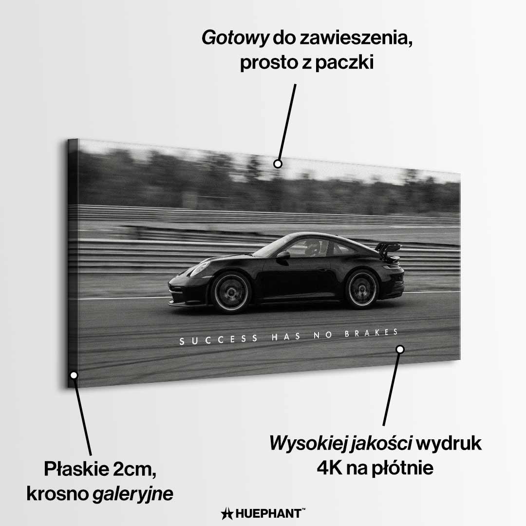 Czarno-biały obraz na płótnie przedstawiający Porsche 911 w szybkim ruchu na torze z napisem Success Has No Brakes. Motywacyjna sztuka ścienna do biura.