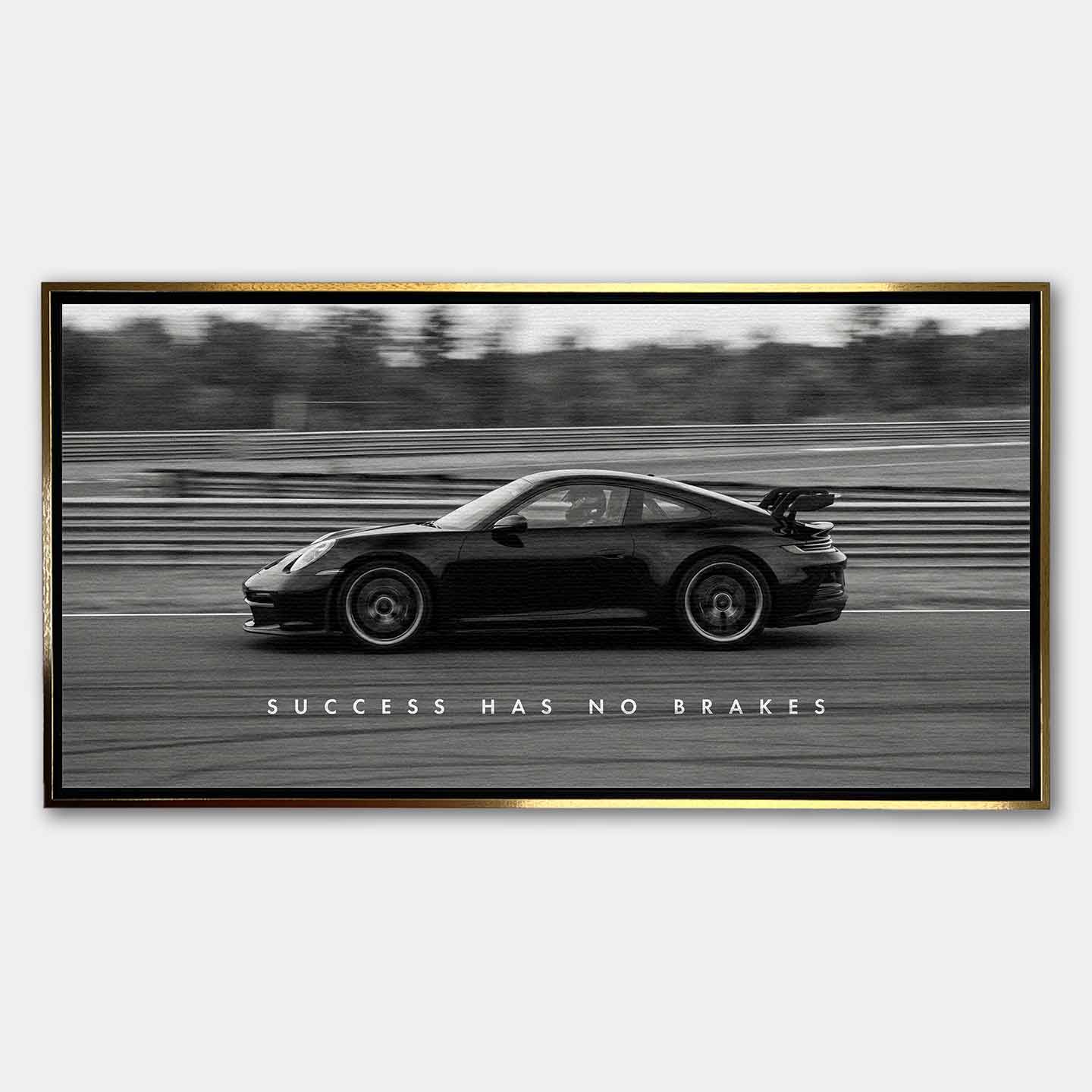 Czarno-biały obraz na płótnie przedstawiający Porsche 911 w szybkim ruchu na torze z napisem Success Has No Brakes. Motywacyjna sztuka ścienna do biura.