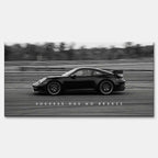 Czarno-biały obraz na płótnie przedstawiający Porsche 911 w szybkim ruchu na torze z napisem Success Has No Brakes. Motywacyjna sztuka ścienna do biura.