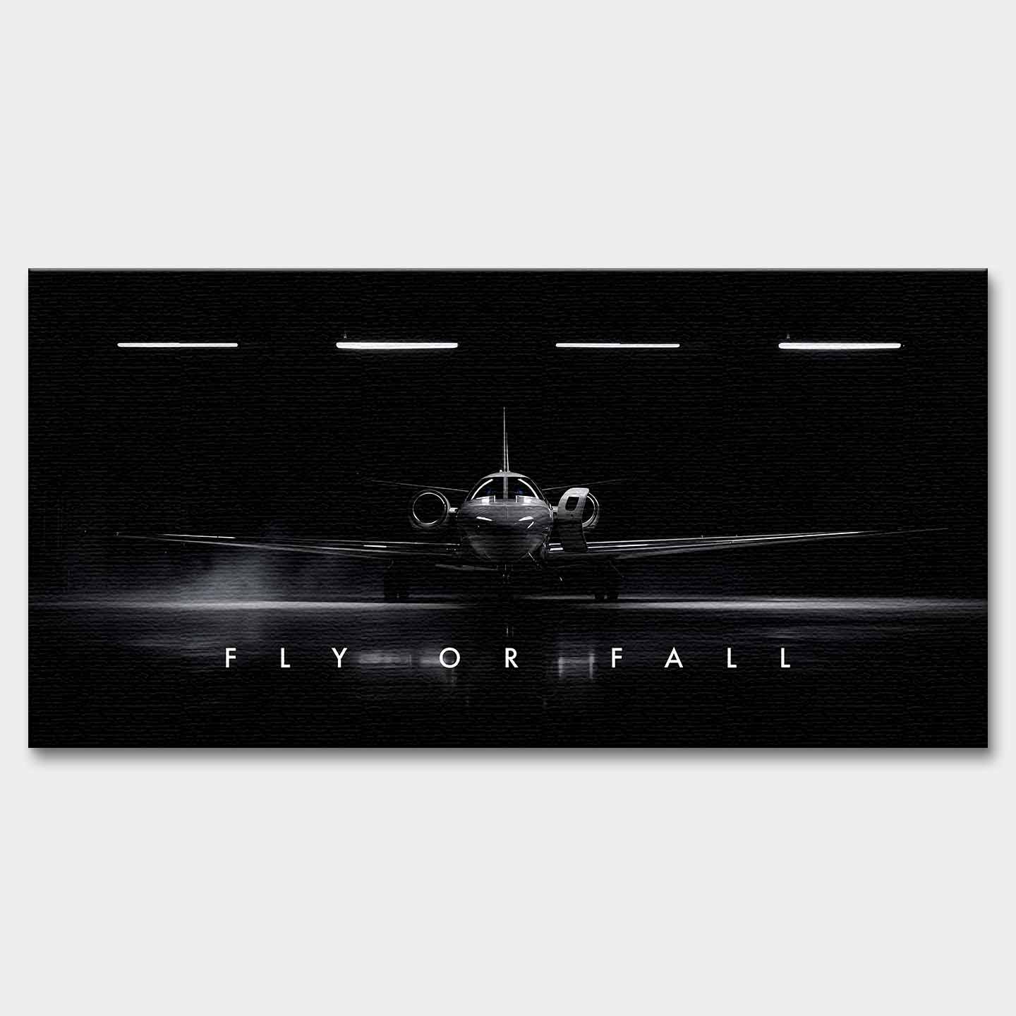 Obraz motywacyjny na płótnie Fly or Fall przedstawiający prywatny odrzutowiec w ciemnym hangarze z napisem „Fly or Fall”, symbolizujący luksus, odwagę i determinację.