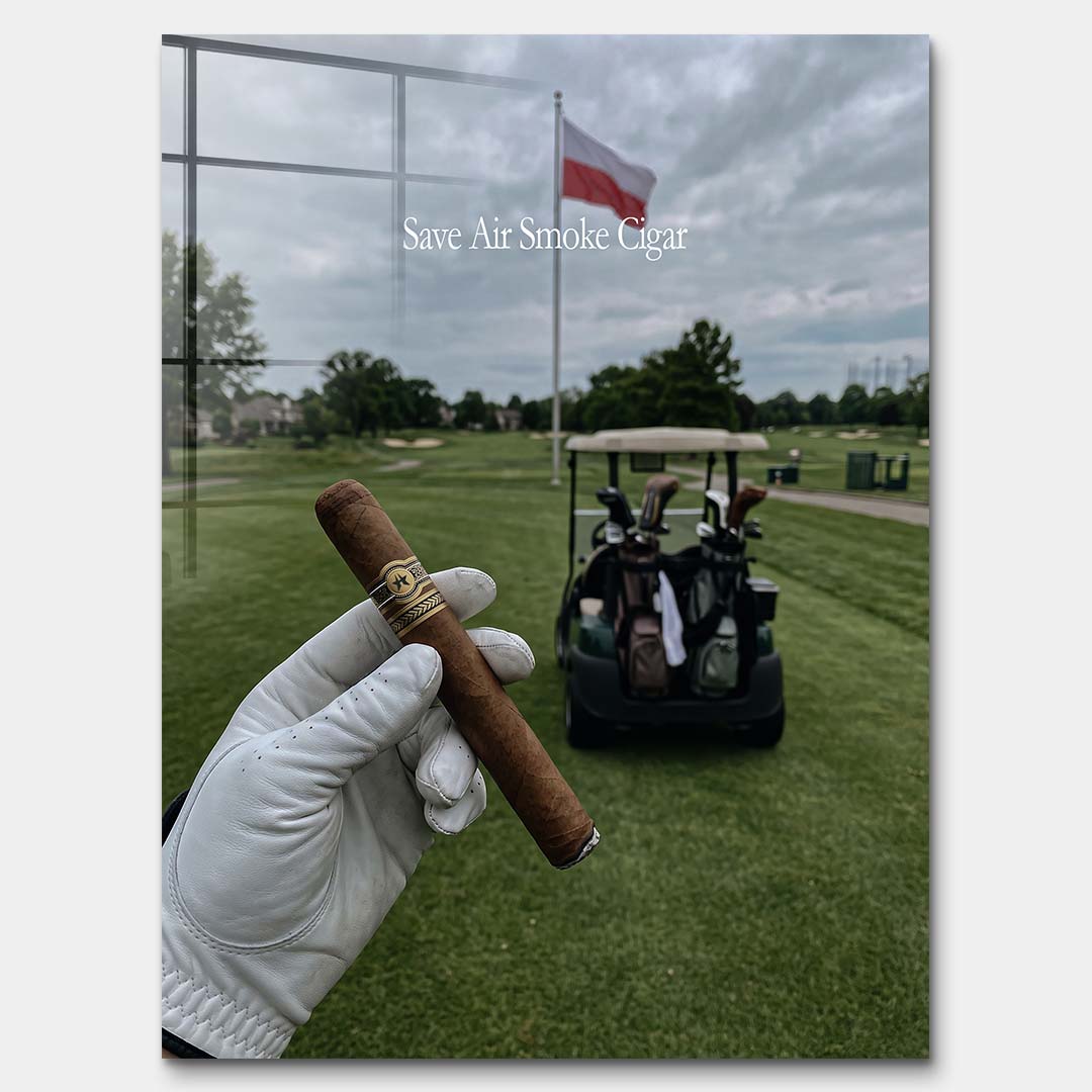 Męski obraz na szkle akrylowym przedstawiający dłoń w rękawiczce trzymającą cygaro na tle pola golfowego z polską flagą. Wydruk galeryjny Huephant.