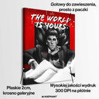 Obraz na płótnie przedstawiający Tony'ego Montanę z filmu „Scarface”, siedzącego na czarnym fotelu na tle czerwonego tła z białym napisem „The World Is Yours”; intensywna scena w czarno-białej kolorystyce z kontrastującymi elementami czerwieni i bieli.