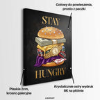 Nowoczesny obraz na płótnie przedstawiający burgera z banknotów, złota i zegarka oraz złoty napis STAY HUNGRY na czarnym tle. Wydruk galeryjny Huephant.