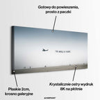 Minimalistyczny poziomy obraz na płótnie z awionetką ciągnącą napis The World Is Yours nad zamgloną plażą z sylwetkami ludzi, wydruk galeryjny.